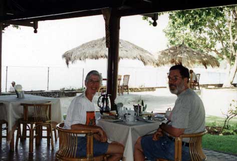 Here's where we ate breakfast every morning. The menu that came with the room was coffee, fresh fruit salad including banana, pineapple and papaya, and a pancake with banana and pineapple. The hawkers would line up along the fence and show things, trying to catch your eye. One morning there were twelve. They don't come onto the hotel grounds. - jpg - 24960 Bytes