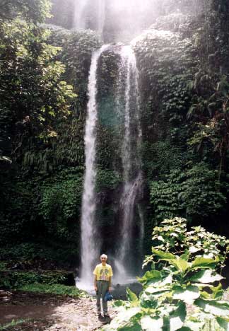 Air Terjun (waterfall) Singang Gila on the north side of Mt. Rinjani. The top part of the falls is taller. It is set in a forest surrounded by upland rice fields. Most of the path is steps and it is a steep climb down, then back up. The guides are boys who live nearby and have a little English. Our young guide lives there and has a dream of building his own losmen, a cheap tourist hotel. Clare Ann slipped on the stone steps as we began to climb back up, and the guide insisted on holding her arm for the whole climb. - jpg - 33030 Bytes