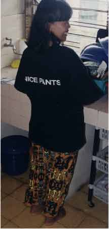 When Duane was last in Singapore he bought some Dockers pants and received a free 'Nice Pants' t-shirt which was given to Tari and Kris who take turns wearing it. This time Ibu Tari was wearing it with pants made from fabric Duane brought from Papua. - jpg - 7605 Bytes