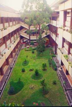 A view of the courtyard inside the structures. The arrangement is two long buildings parallel to the street with this open space between them. The staircase at the end is one of two flanking a covered atrium. - jpg - 15292 Bytes